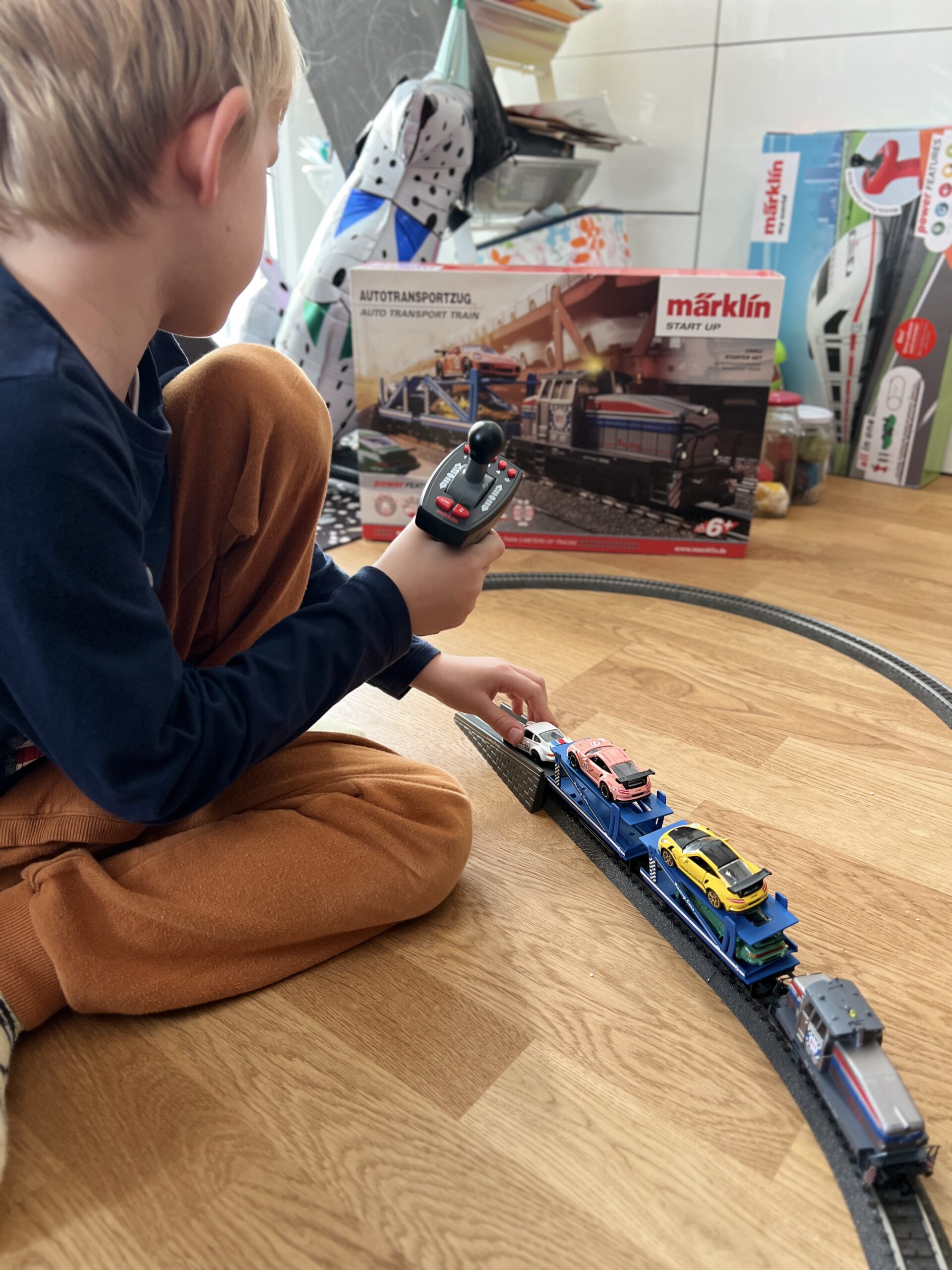 Junge spielt mit Märklin Lokomotive mit Autotransportzug
